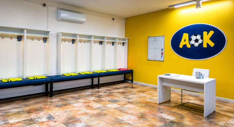 Τα αποδυτήρια του γηπέδου «Μαρίνος Δαστερίδης» με το σήμα ΑΟΚ και τον πίνακα τακτικής